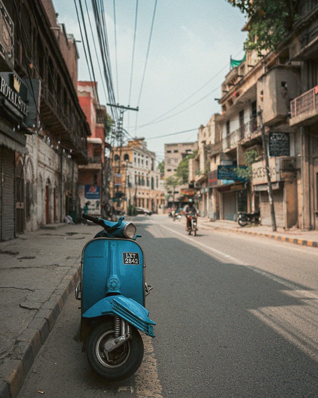 A shallow depth of field focusing on the Vespa Scooter. The post was more about the scooter than the street. 